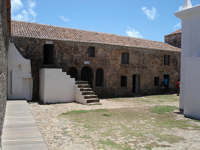 Courtyard view of stone buildings with clay tiled rooves.