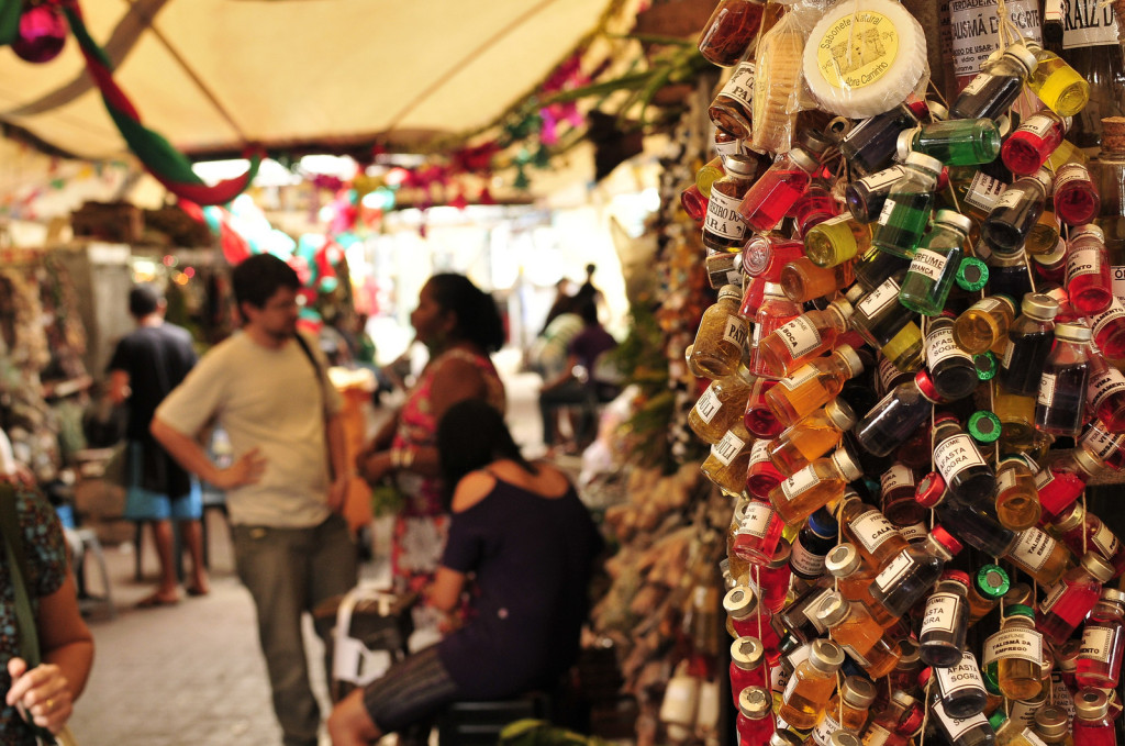 Soaps and bottles of perfumes are strung up in a column for sale under a tent.