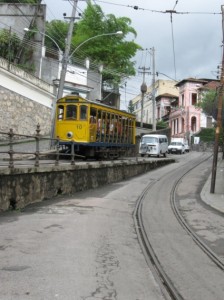 An aging yellow trolley on a winding street.