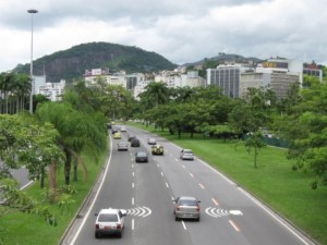 A highway flanked by green grass and trees