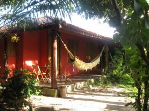 A small, red inn with a hammock in front