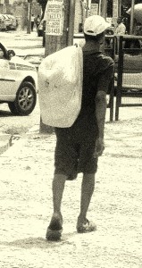 Man on street carrying sack