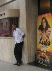 Man stands in front of movie poster