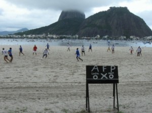 Boys playing soccer on a beach 