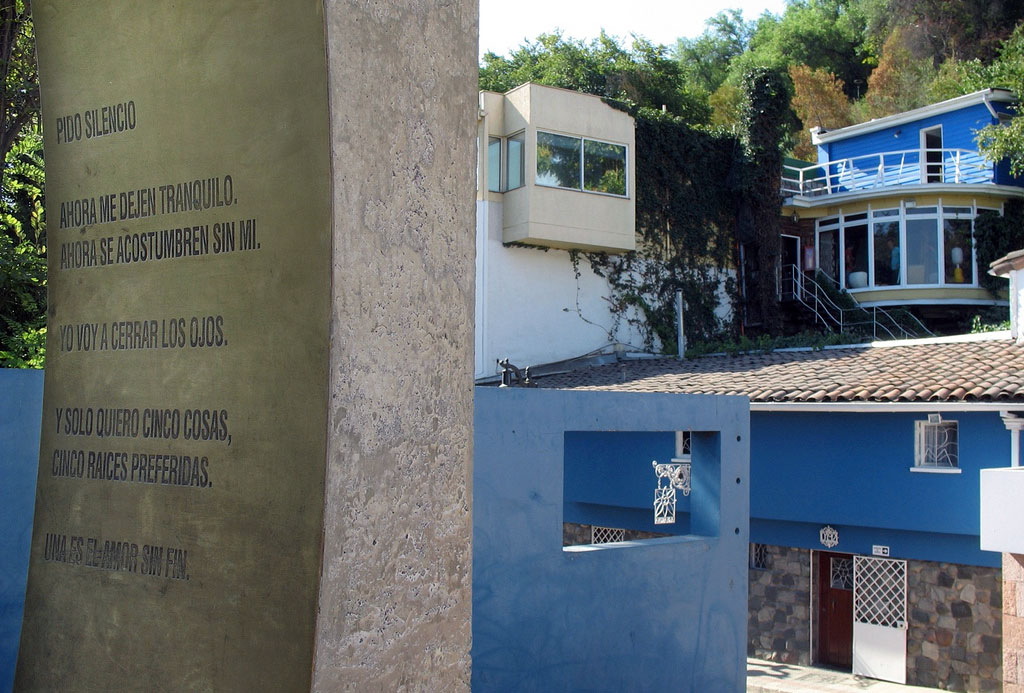 A stone etched with the words to Neruda's poem with a view of La Chascona across the street.