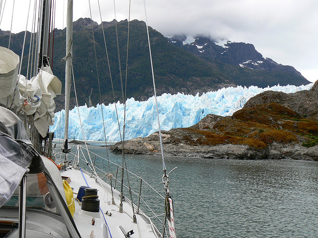 A wall of bright blue glacial ice viewed from on deck a boat at Laguna San Rafael.