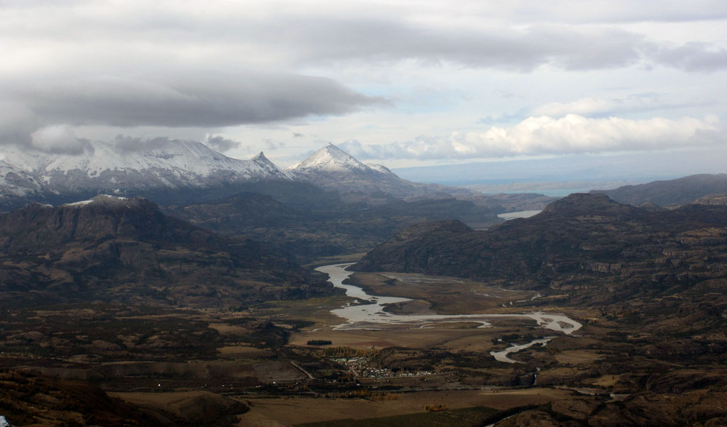 View from the mountains overlooking a river snaking through the valley.