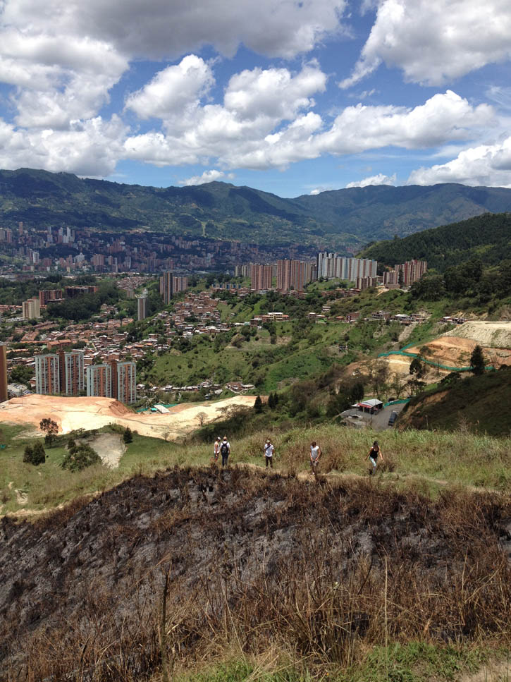 Hikers pause on a small ridge overlooking Cali in Colombia.