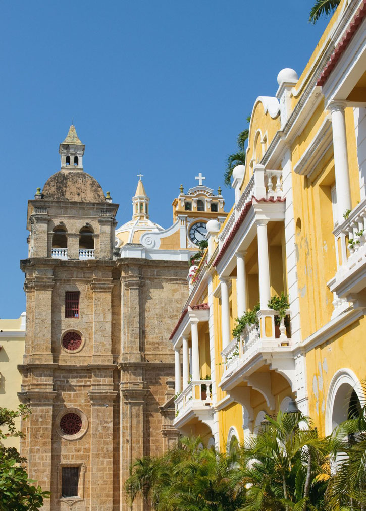 Church and yellow colonial building in historic Cartagena, Colombia.