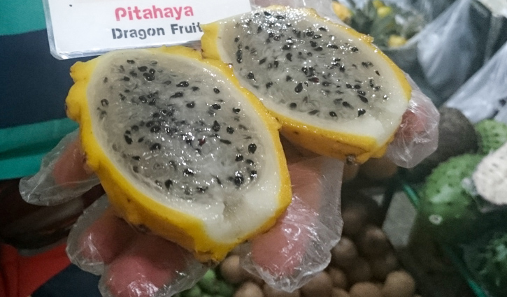 A Medellín market vendor shows off a sliced pitahaya, or dragon fruit.