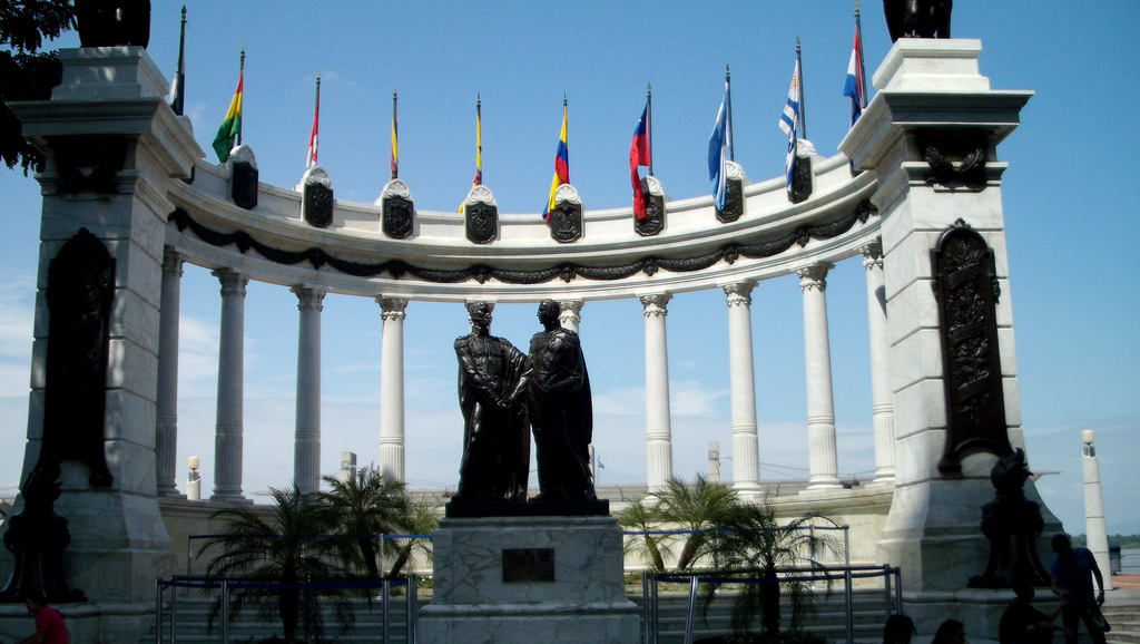 The statue is set in a semi circle of columns topped with flags.