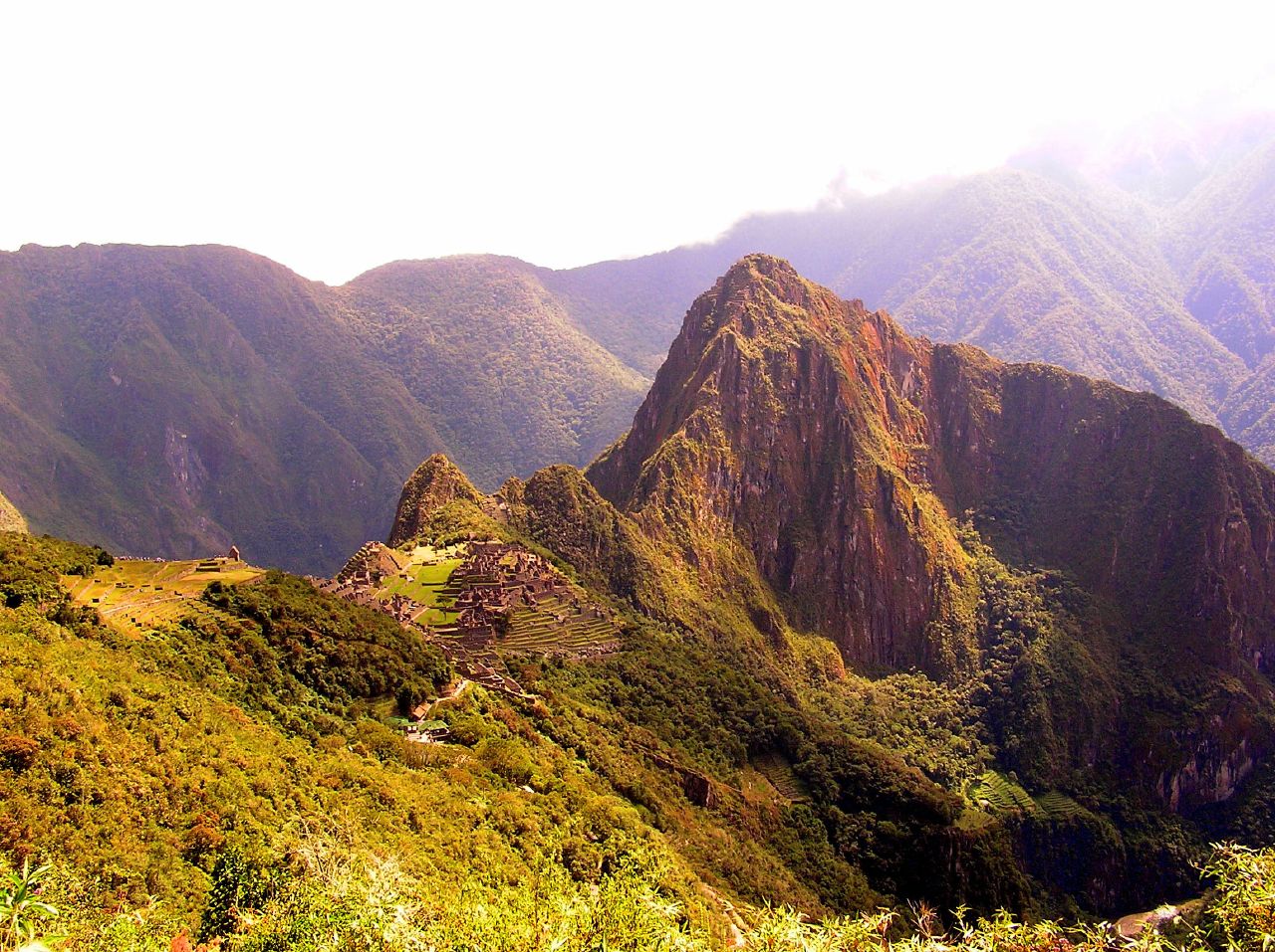 The terraced structure of Machu Picchu seems dwarfed by the mountains around it.