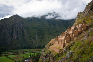 The stone walls of ancient storehouses built terraced into a cliffside.