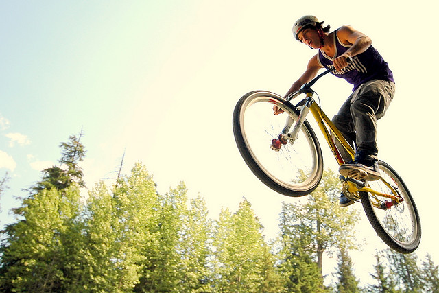 Up angle shot of a mountain biker getting air from a jump.