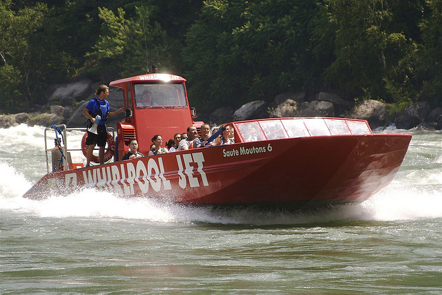 A red jet boat makes waves on the Niagara river.
