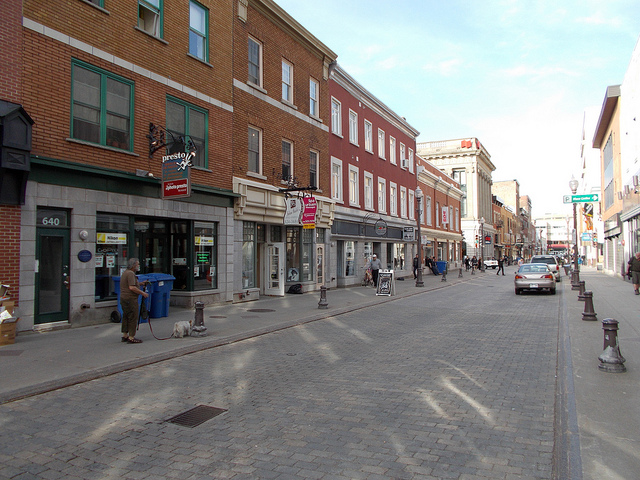 View of a quaint shopping district home to many boutique stores housed in brick buildings.