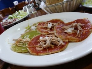 Sopes made with red and green sauces on a plate.