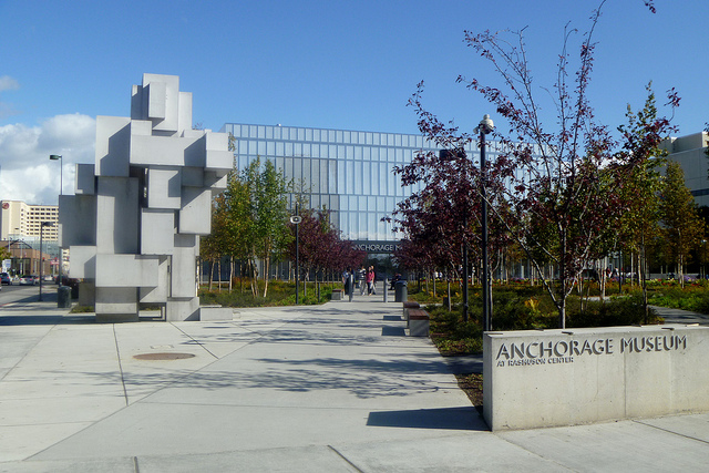 View of front of the Anchorage Museum with a large structure of interlocking cubes on the sidewalk.