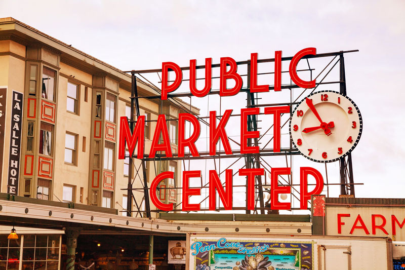 Pike Place market sign reading Public Market Center with a clock.