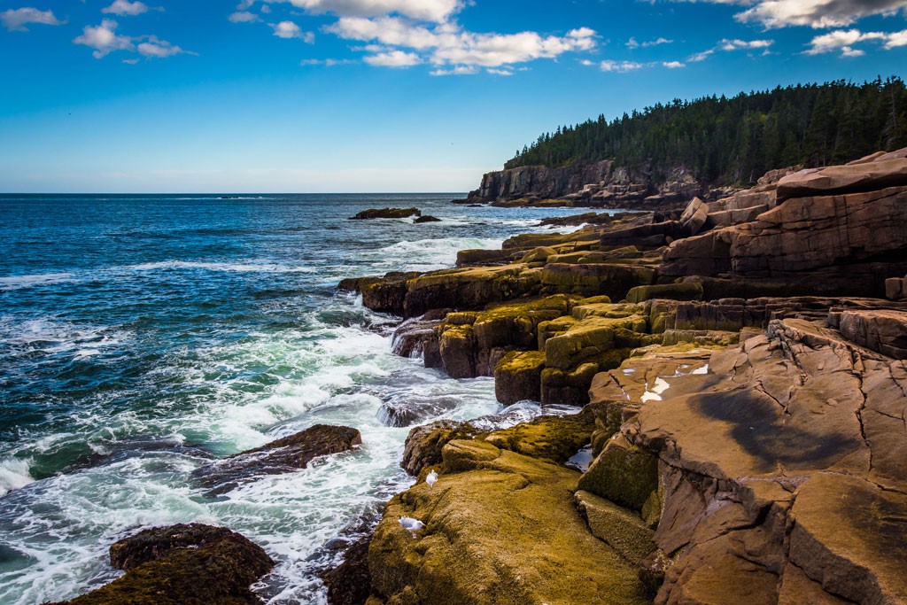 Ocean waves crashing gently on the rocks of Otter Cliff in Acadia National Park.