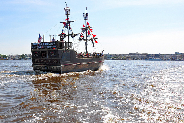 A ferry styled like a pirate ship cruises through the water.