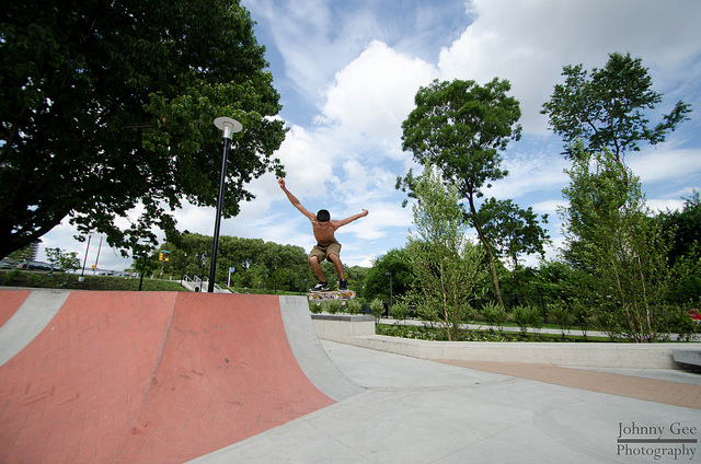 A skateboarder does a flip on a quarter pipe.