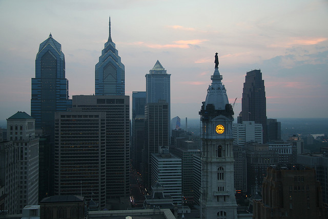 View of the city skyline at dusk with the clock tower of city hall the brightest spot.