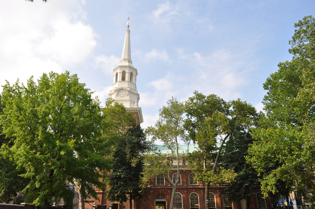 View of the church built of red brick with a tall white spire.