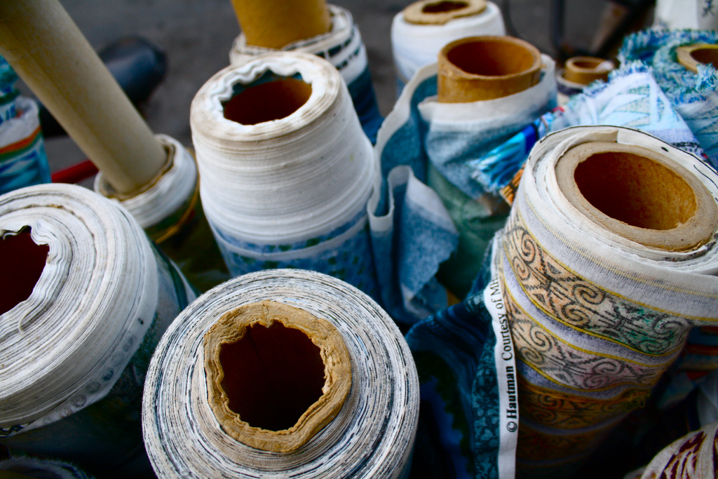 View of the top of a cluster of bolts of heavy fabric.