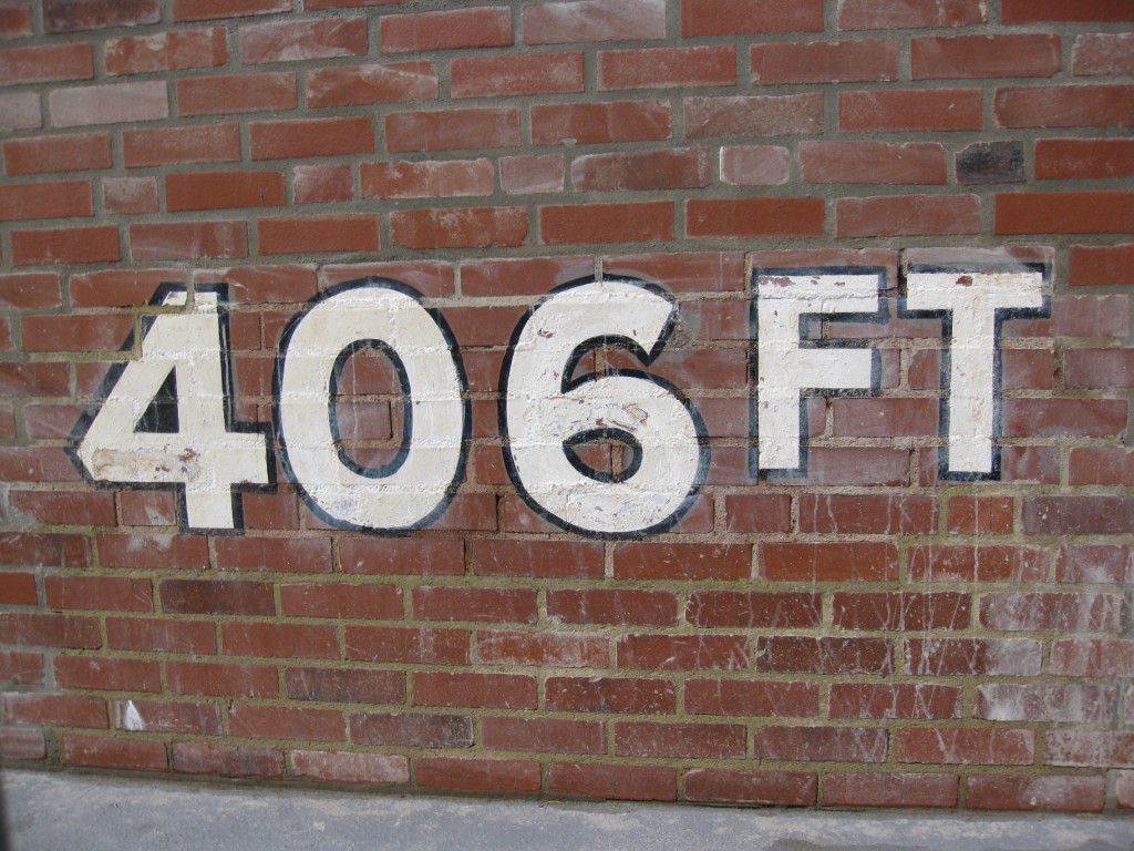 A brick wall with '406 ft' painted on it in large block letters.