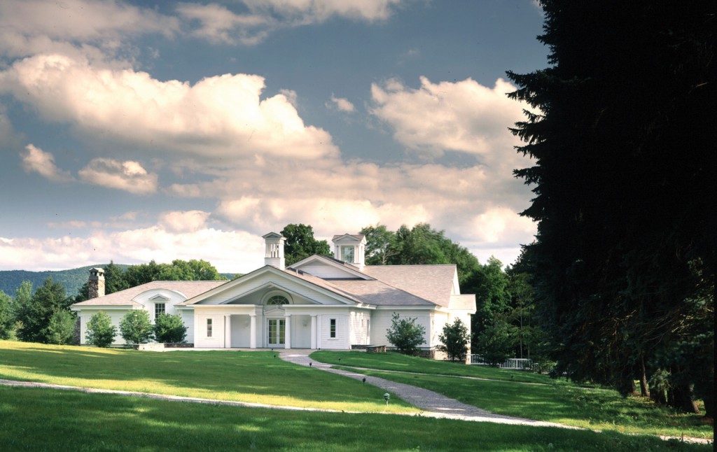 The single story white building of the Norman Rockwell Museum surrounded by lush grass.