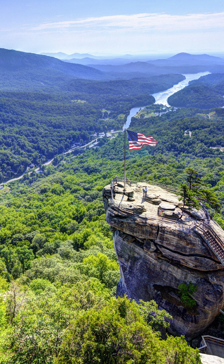 An American flag flies at the top of Chimney Rock overlooking Chimney Rock State Park in North Carolina.