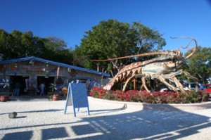 A giant lobster statue sits out front of a single story building.