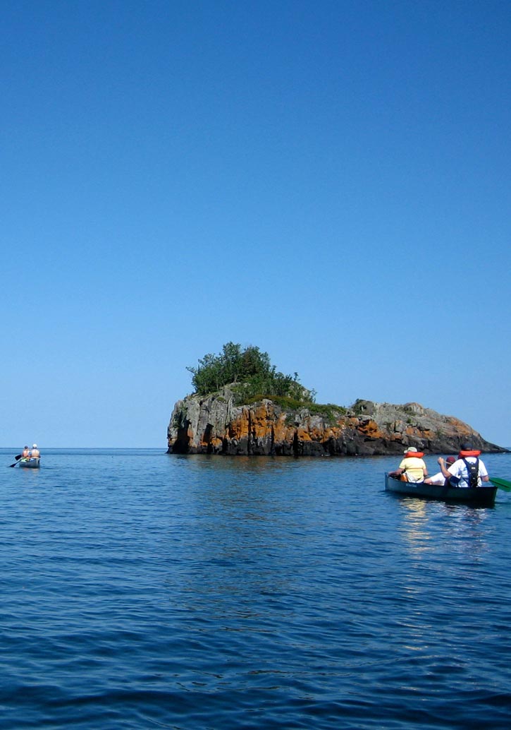 Canoers paddling through small rocky islands at Isle Royale National Parks.