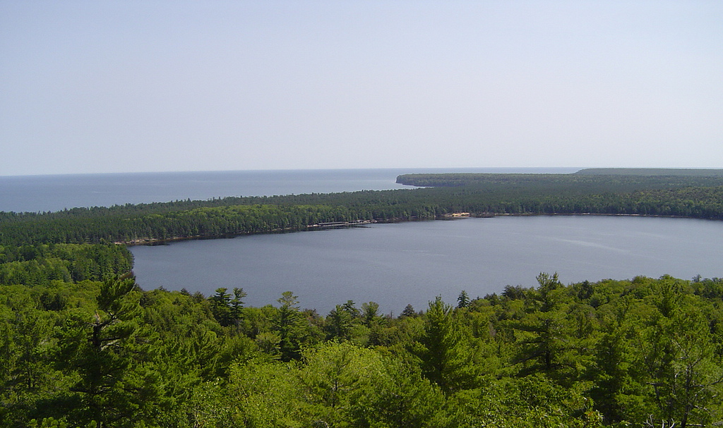 View down at Lake Superior and another lake across a sea of trees.