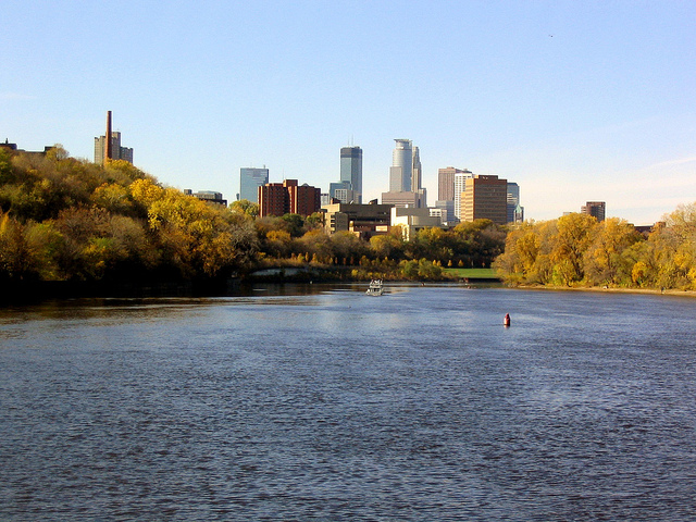 View across the water of the city skyline visible above the tree-lined banks.