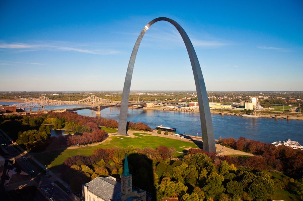 View of the arch rising up high into the sky next to the river.