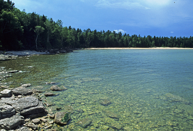 Rocks are clearly visible in shallow water at the edge of Lake Michigan in Newport State Park.
