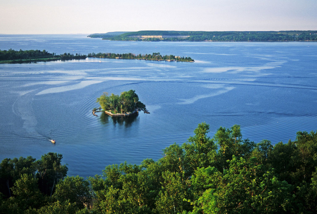 View of a small island in the bay with a boat leaving a wake.