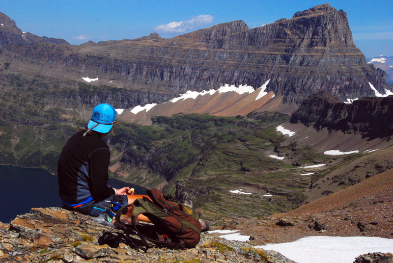A hiker sits overlooking a lake in Glacier National Park.