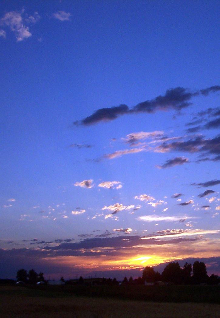 A striking sunset with darkening clouds on a violet sky in Bozeman, Montana.