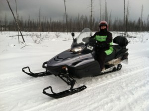 Laura bundled up and ready to ride on a snowmobile.