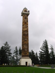 The Astoria Column monument rises up like a smoke stack.