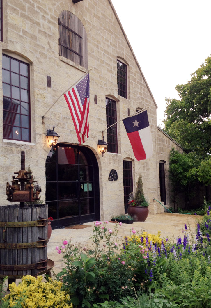 The state and US flag hang in front of rustic Becker Vineyards in the HIll Country.