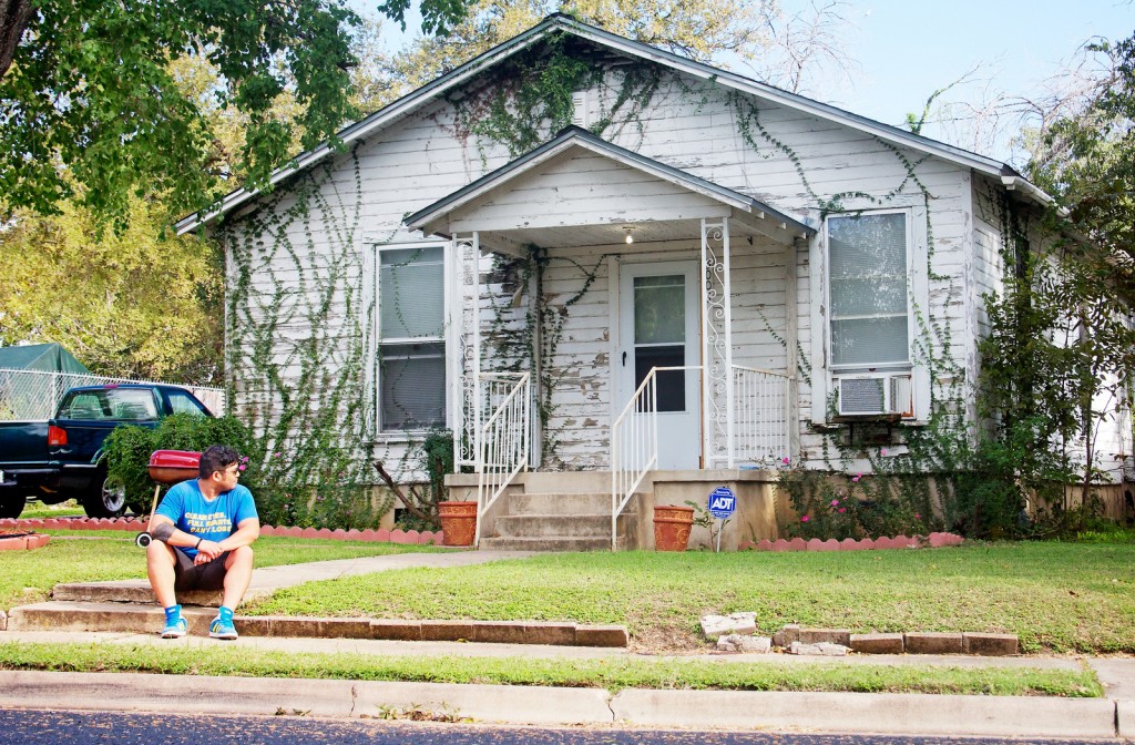 A simple cottage style white house with vines growing up the walls.