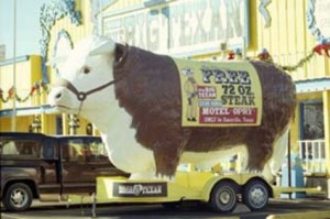 A large statue of a cow bearing a sign reading Free 72oz Steak.