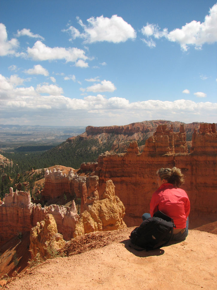 A woman sits at the edge of an amazing scenic overlook in Bryce National Park.