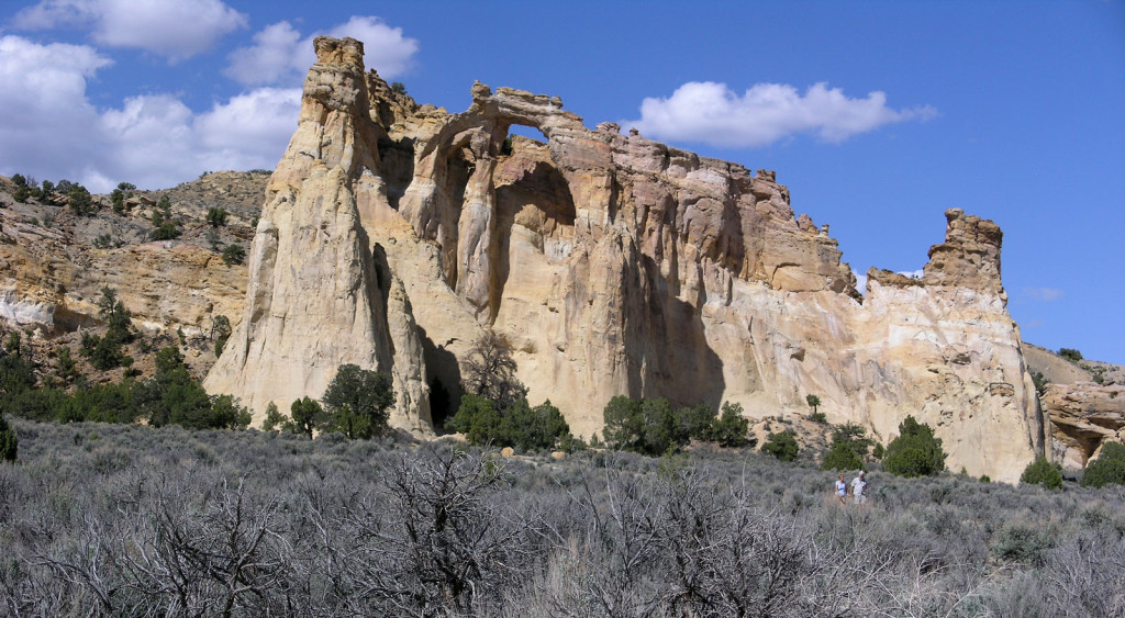 A large standalone arch with double windows surrounded by dry scrub brush.