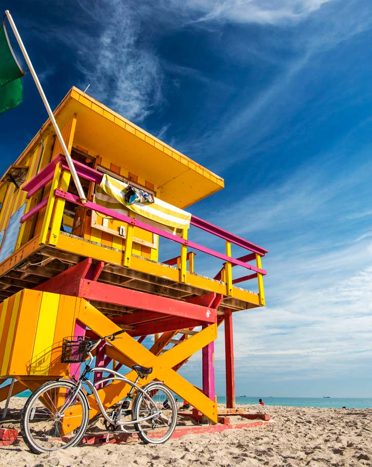 A bike leans against a colorfully painted lifeguard station in Miami's South Beach.