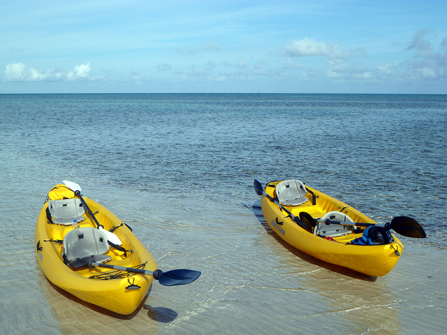 Two yellow kayaks on the beach.
